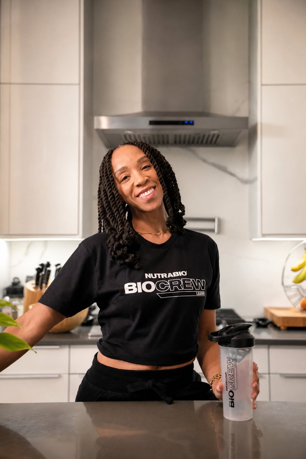 Dr. Shari wearing a NutraBio BioCrew Leader shirt, holding a NutraBio shaker bottle